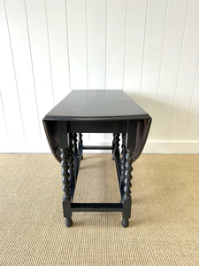 An Antique English Ebonized Country Oak Drop Leaf Gate Leg Table