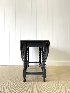 An Antique English Ebonized Country Oak Drop Leaf Gate Leg Table