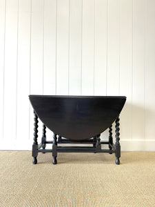 An Antique English Ebonized Country Oak Drop Leaf Gate Leg Table