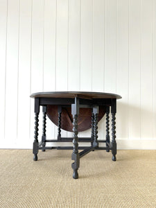 An Antique English Ebonized Country Oak Drop Leaf Gate Leg Table