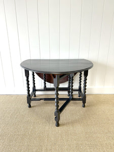 An Antique English Ebonized Country Oak Drop Leaf Gate Leg Table