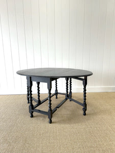 An Antique English Ebonized Country Oak Drop Leaf Gate Leg Table