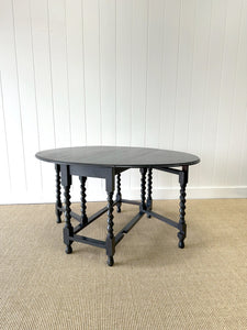 An Antique English Ebonized Country Oak Drop Leaf Gate Leg Table