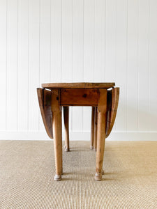 An Antique Pine Oval Drop Leaf Kitchen Dining Table with Spoon Feet